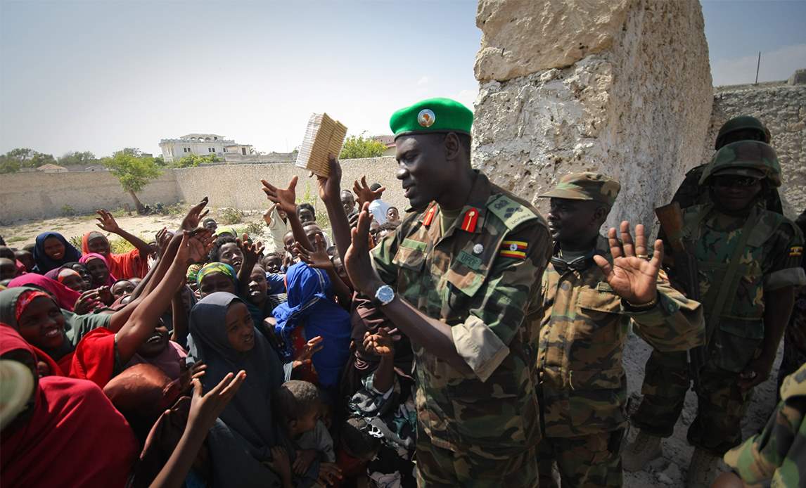 Brigadier Paul Lokech, Ugandan Contingent Commander serving with the African Union Mission in Somalia (AMISOM), hands out free packets of biscuits to children near to where Ugandan soldiers and doctors serving with the African Union Mission in Somalia (AMISOM) were providing free medical check-ups and treatment in the Kaaran district of the Somali capital Mogadishu.