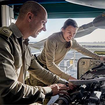 To elever på løjtnantuddannelser besigtiger en motor.